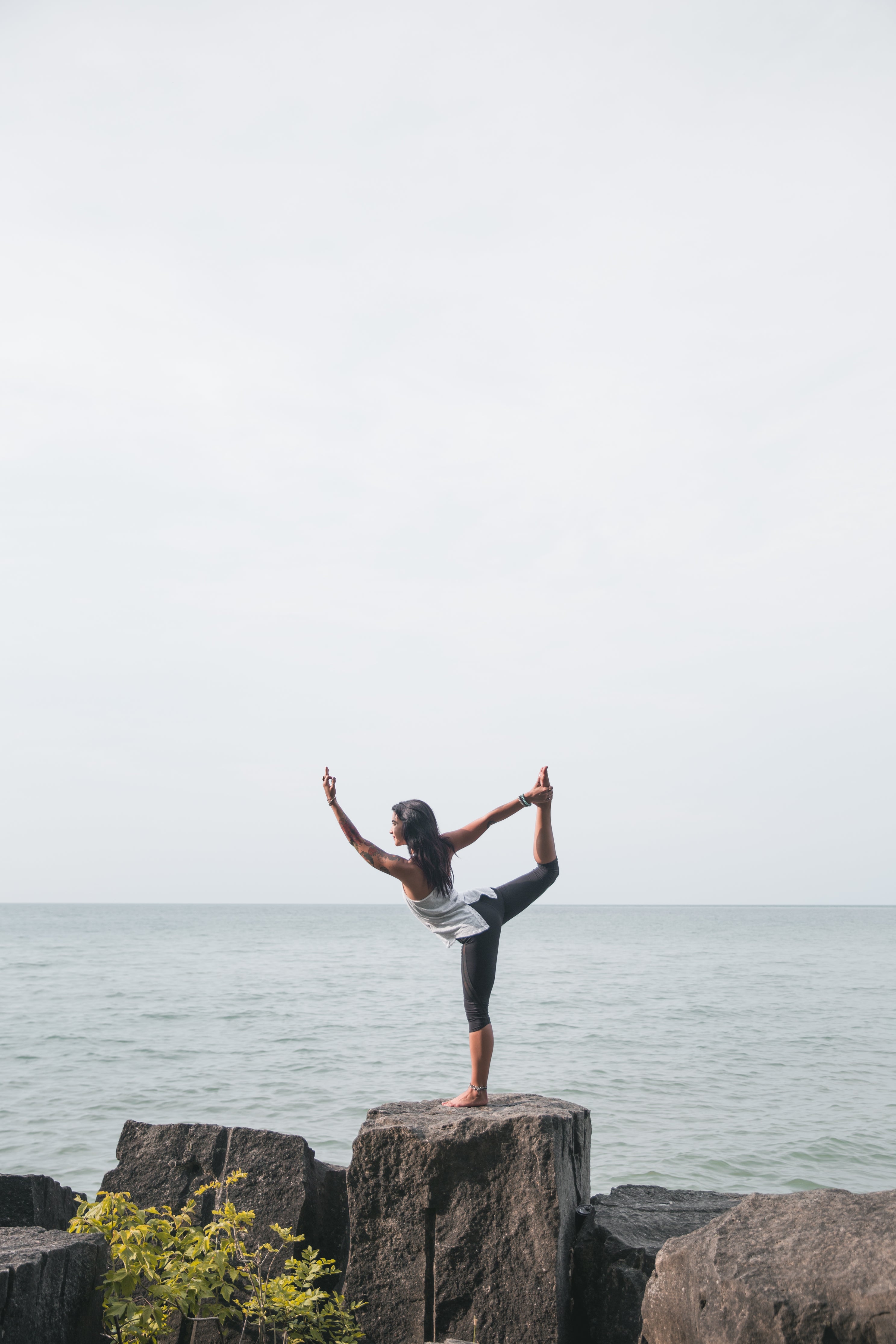 female in yoga pose outdoors on rock